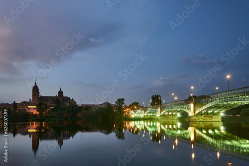 Cathedral of Salamanca at night and Enrique Esteban Bridge view from the Tormes River, Salamanca City. photo