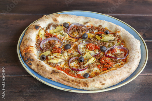 Pizza italienne à la viande de boeuf hachée, aubergines et sauce tomate faite maison dans une assiette en céramique. Gros plan. 