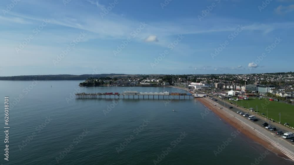 Paignton, Torbay, South Devon, England: DRONE VIEWS: Ascending drone view of Paignton Pier, Paignton Green and Torbay Coastline. Paignton is a popular UK holiday resort (Clip 1). Paignton, Torbay, South Devon, England: DRONE VIEWS: Ascending drone view of Paignton Pier, Paignton Green and Torbay Coastline. Paignton is a popular UK holiday resort (Clip 1).