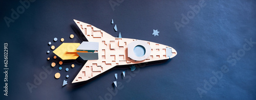 illustrazione di modellino di razzo spaziale costruito con ritagli di carta colorata, sfondo di carta blu scuro photo