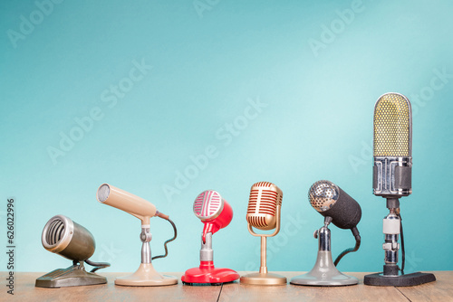 Foto Vintage old microphones for press conference or interview on the oak table front gradient mint blue background