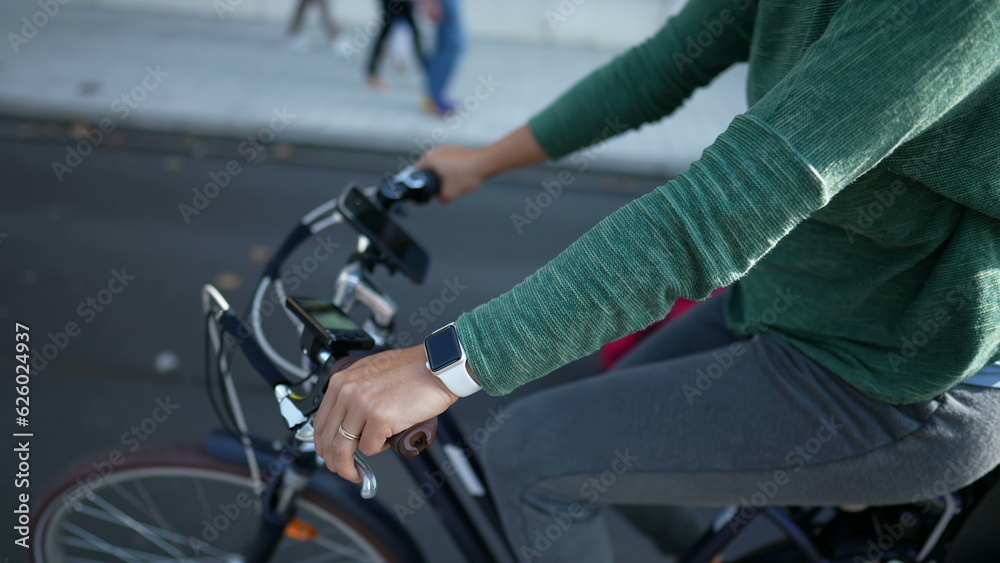 Cyclist mother riding bicycle in street with toddler in back seat Cyclist mother riding bicycle in street with toddler in back seat