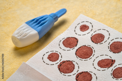 lancet and dry blood spots on a fiber filter for laboratory analysis, home health testing concept photo