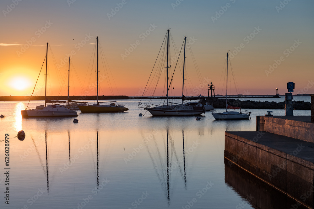 Sunset in the port of Juan Lacaze, with several sailboats anchored in the foreground