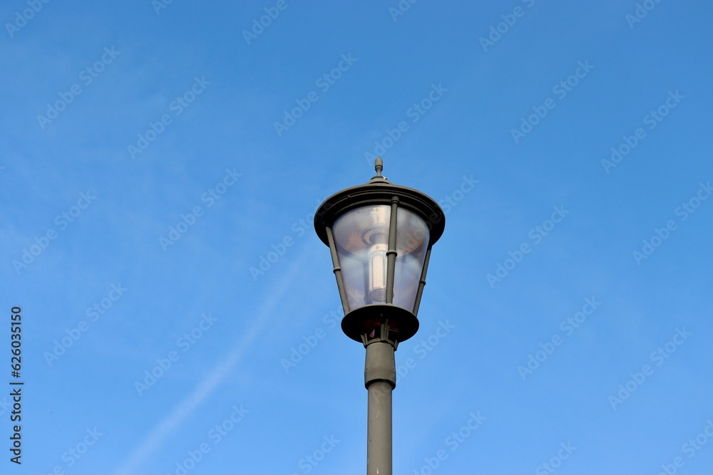 The black metal light post with the blue sky background.