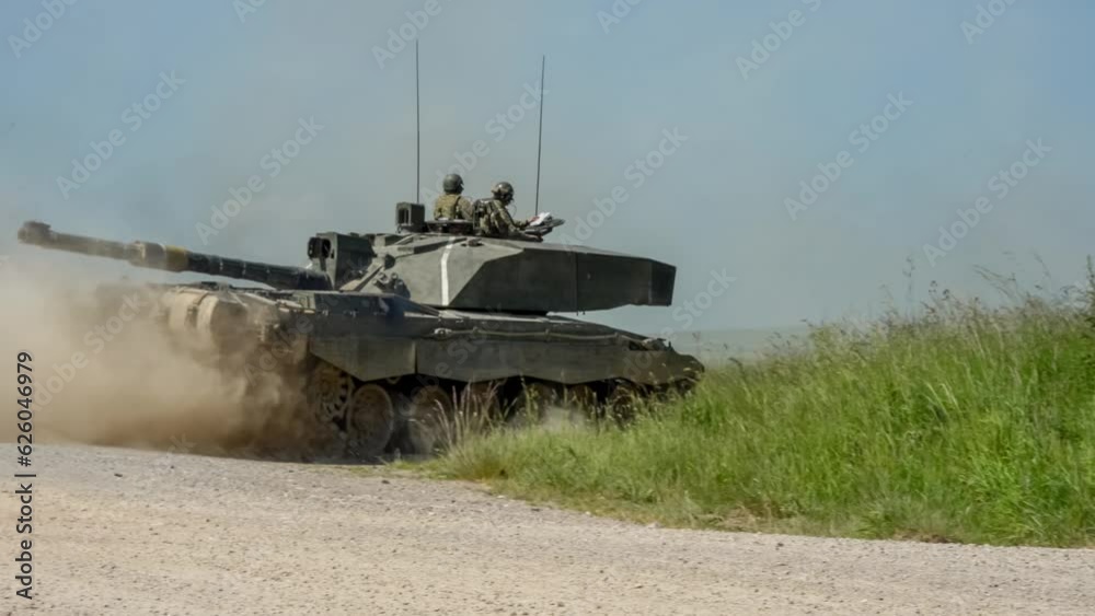 Commander and gunner directing a British army Challenger 2 II FV4034 tank in motion along a dust track on a military exercise, Wiltshire UK Commander and gunner directing a British army Challenger 2 II FV4034 tank in motion along a dust track on a military exercise, Wiltshire UK