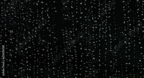Water droplets on the black glass. Shiny water drops on black surface.