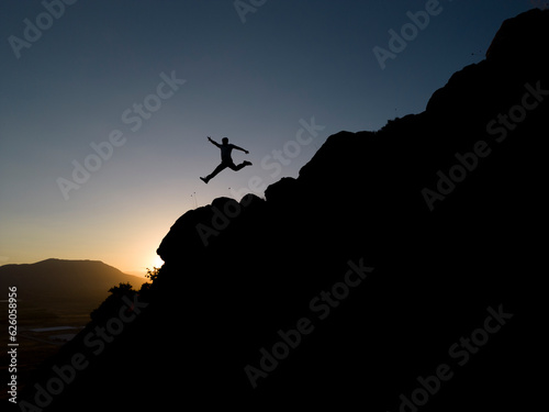 The dynamic jump of the brave, fearless and crazy adventurer on the cliffs