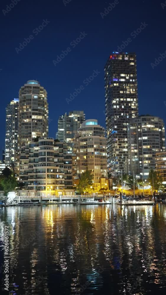 View on downtown of Vancouver at night. Buildings are reflected in the water View on downtown of Vancouver at night. Buildings are reflected in the water