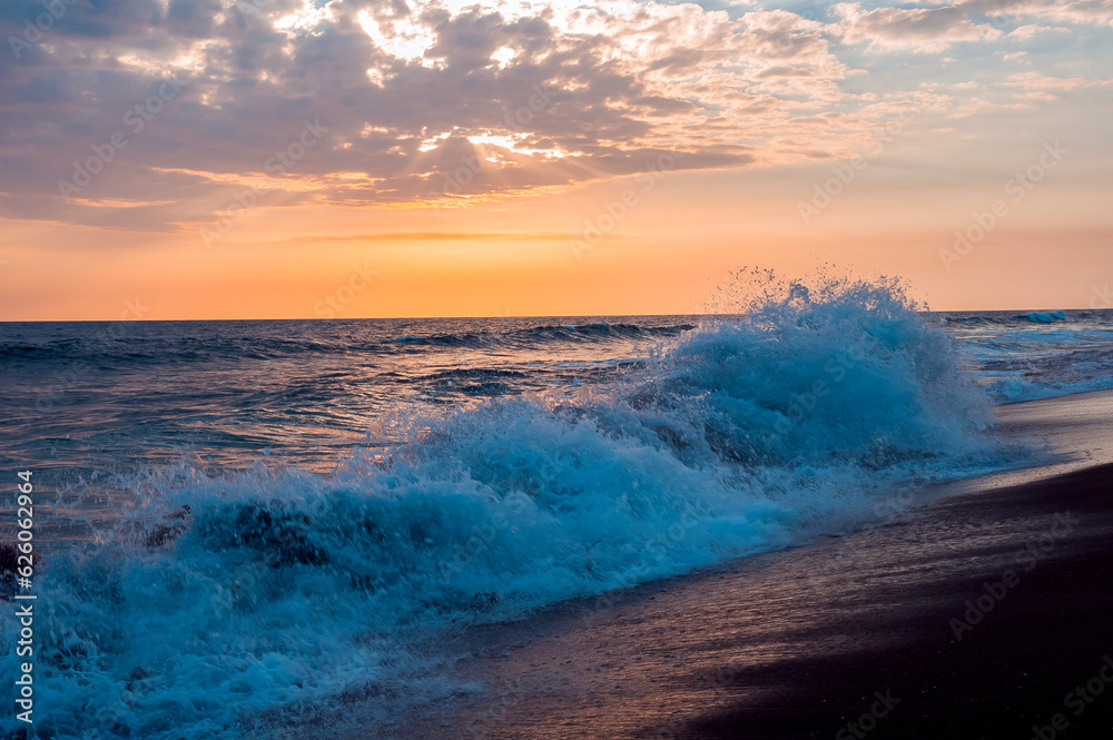 Φωτογραφία Waves on the shore of black sand beach of volcanic origin on the coast of Guatemala, sunset