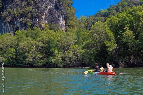 Two people, a guy and a girl, are kayaking in the tropics on the lake, tourism, travel