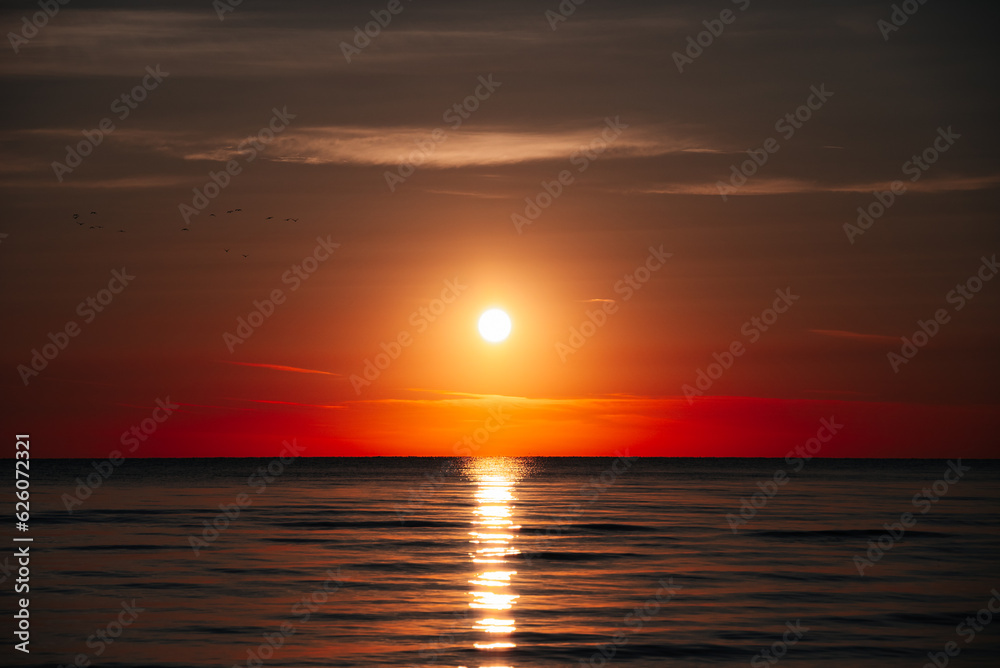 Rays Of Rising Sun Create Golden Sheen On The Water Surface Of Ocean, As If Ocean Becomes Crystal And Noble. Sunrise On Beach Symbolizes Beginning Of New Day, Hope And Awakening Of Nature To Life.