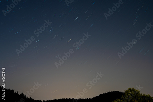 Fototapeta Naklejka Na Ścianę i Meble -  Stars over trees at night, long exposure.