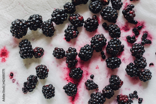 blackberries bleeding pink juice on white papertowel photo