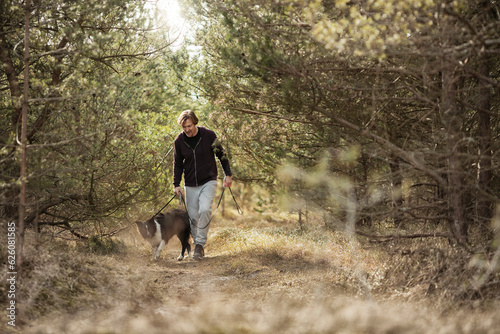 Mature man jogging in the forest with his border collie dog © Geber86