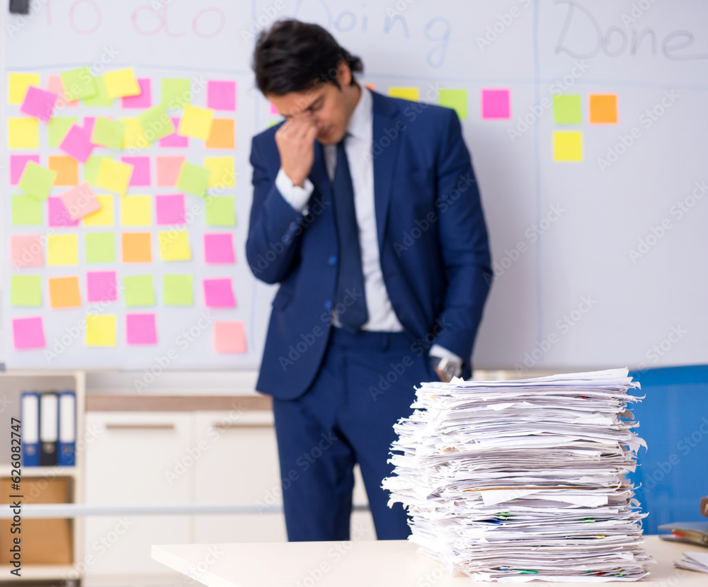 Young handsome employee in front of whiteboard with to-do list Young handsome employee in front of whiteboard with to-do list