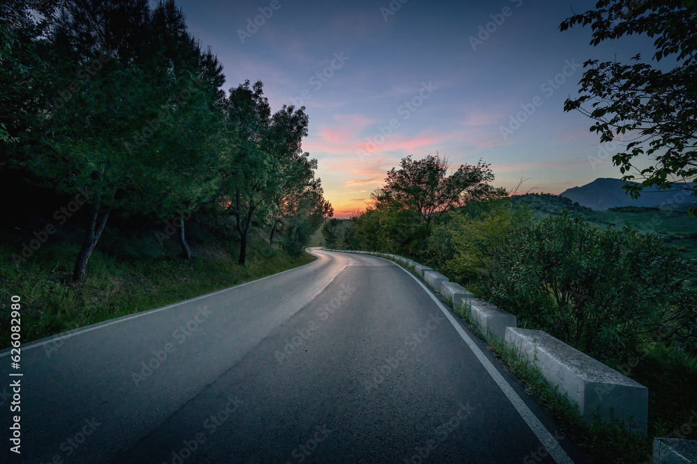 Asphalt road at sunset - Zahara de la Sierra, Andalusia, Spain Asphalt road at sunset - Zahara de la Sierra, Andalusia, Spain