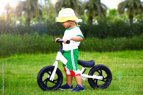 Boy riding balance bike on dirt path in the park