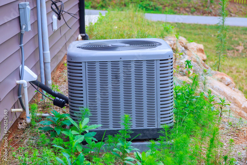 There is an air conditioning unit installed on near house as part of outside air conditioning system