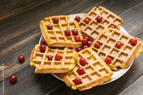 Dish with delicious Belgian waffles on a wooden background, close-up.