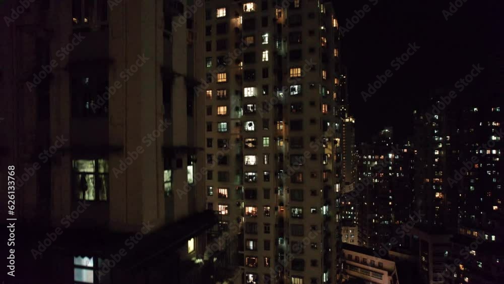 Vol au dessus de la ville de Hong Kong, China, Asie  au milieu des bâtiments et gratte-ciel et au-dessus des tours immenses et de rues illuminées pendant la nuit.
