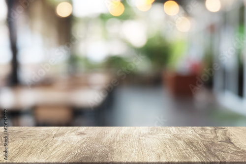 Empty dark wooden table in front of abstract blurred boken bankground of restaurant. Can used for display or montage your products. Mock up for space. photo