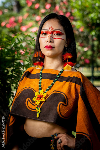 beautiful young peruvian woman of the yanesha culture posing with dresses, jewelry, makeup, clothes and accessories designed with Asháninka iconography in nature