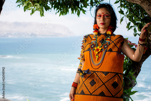 beautiful young peruvian woman of the yanesha culture posing with dresses, jewelry, makeup, clothes and accessories designed with Asháninka iconography in nature