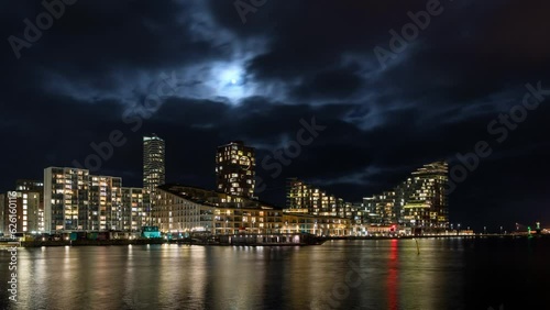 The moon rising between clouds above the new residential part of Aarhus, the second largest city in Denmark. Timelapse clip.