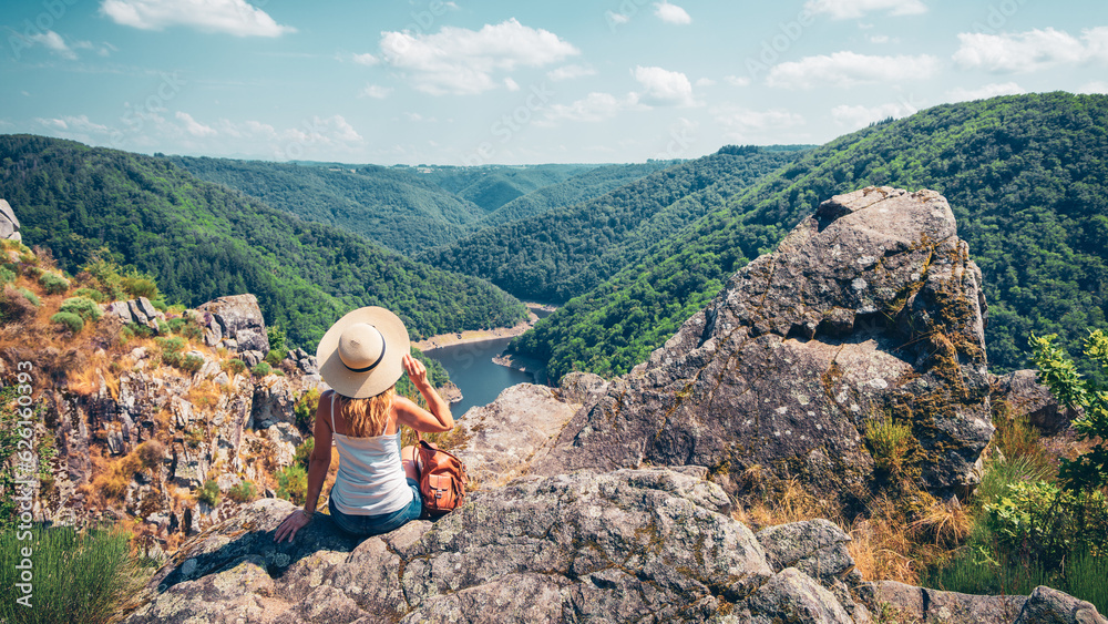 Woman sitting on peak enjoying beautiful view- travel,adventure, wanderlust concept ( Dordogne in France)