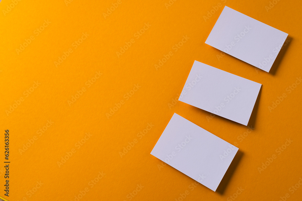 White business cards with copy space on orange background White business cards with copy space on orange background