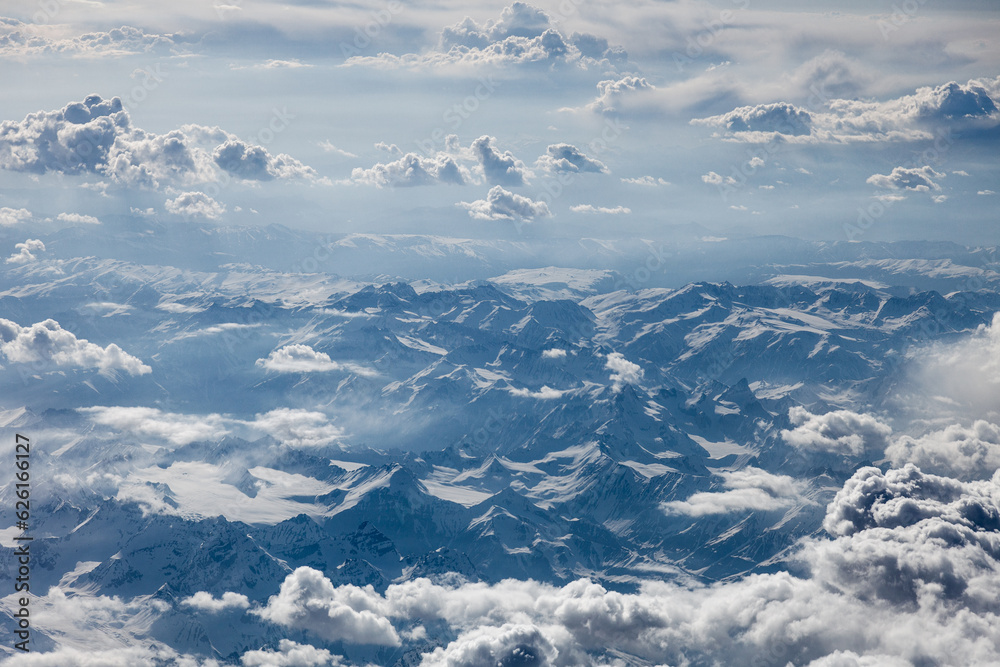 View from the window of the plane on the tops of the mountains of our beautiful planet