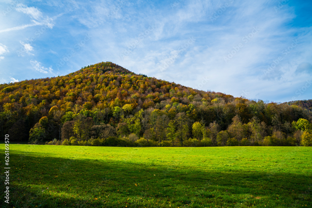 Germany, Colorful autumn mood forest trees nature landscape meadow mountain in bad urach near waterfall with blue sky and sun