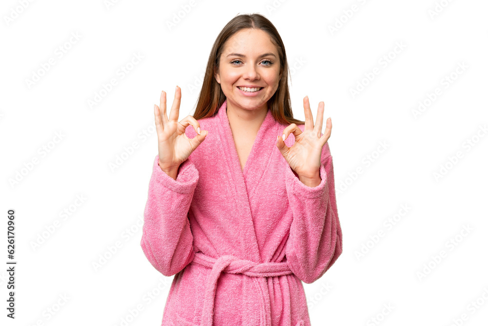 Young woman in a bathrobe over isolated chroma key background showing an ok sign with fingers Young woman in a bathrobe over isolated chroma key background showing an ok sign with fingers