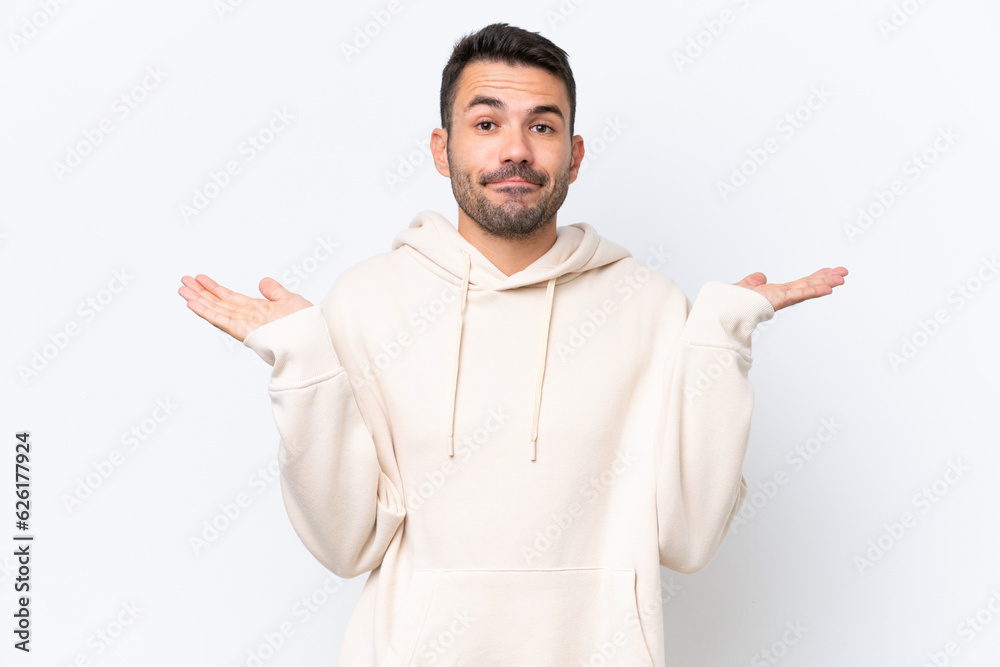 Young caucasian man isolated on white background having doubts while raising hands