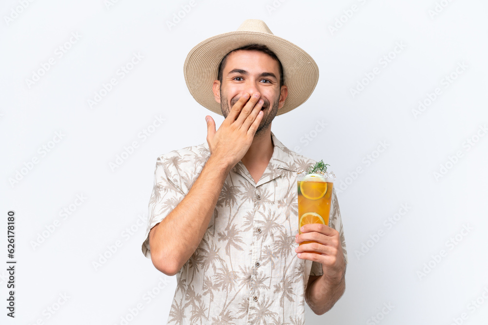 Young caucasian man holding a cocktail isolated on white background happy and smiling covering mouth with hand Young caucasian man holding a cocktail isolated on white background happy and smiling covering mouth with hand