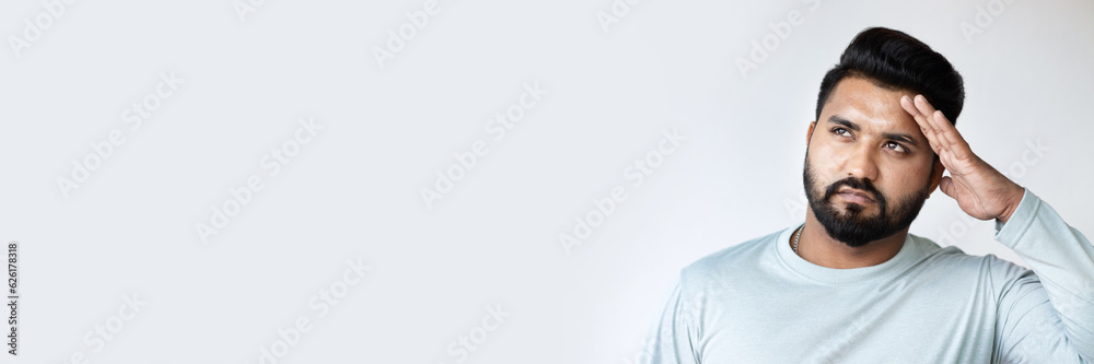 Fototapeta premium Young Indian man thinking, planning, finding a good idea