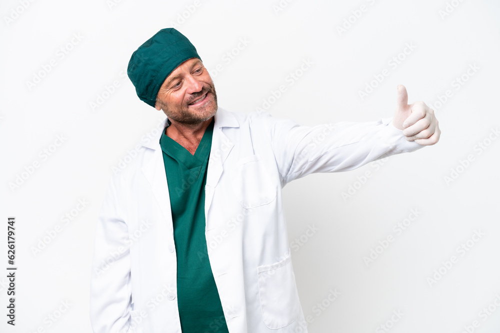Middle age surgeon in green uniform isolated on white background giving a thumbs up gesture Middle age surgeon in green uniform isolated on white background giving a thumbs up gesture