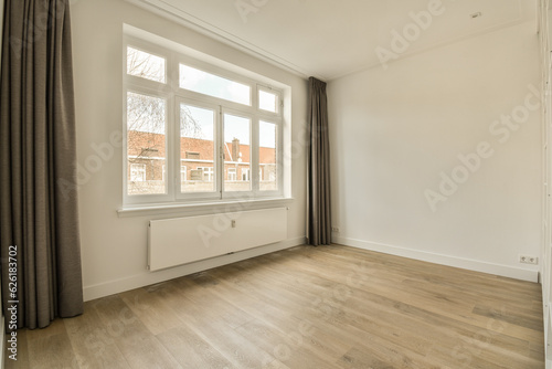 an empty room with wood flooring and large windows looking out onto the street in front of the apartment building