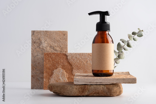 Mock up brown glass bottle on a stone podium