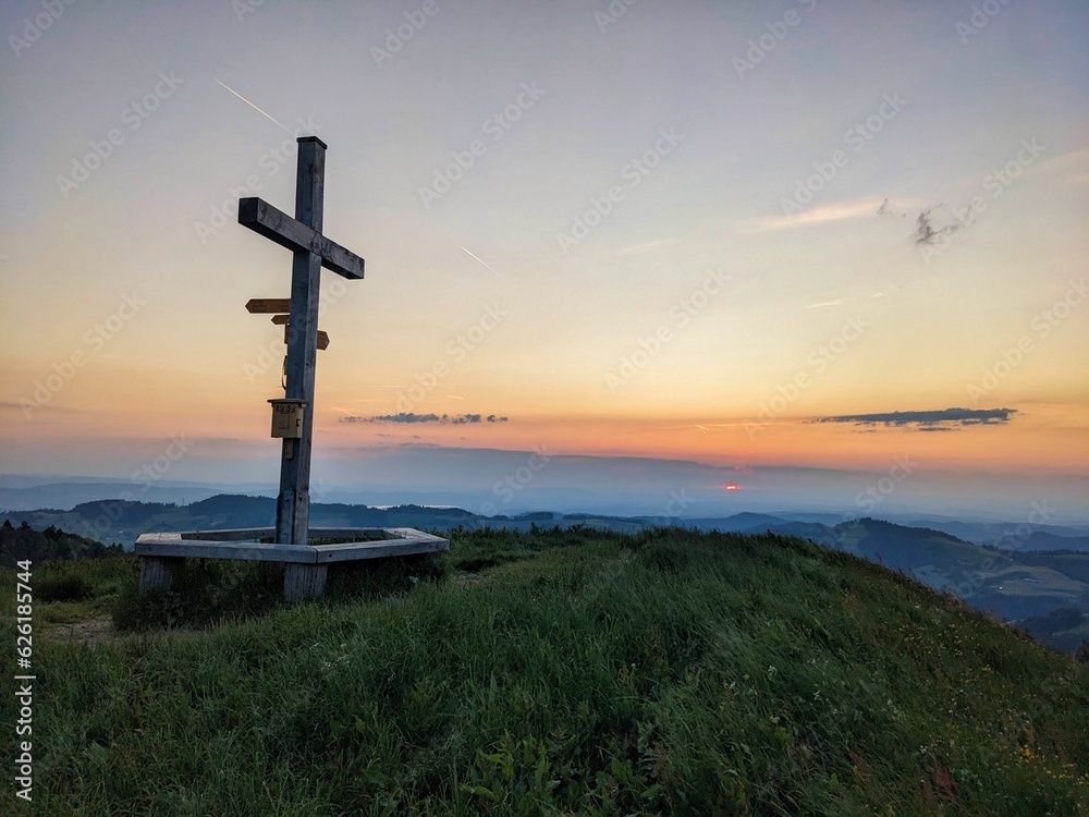 Summit cross on the Hüttchopf in the Zurich Oberland. Sunset on the grass hill above Fischenthal. High quality photo Summit cross on the Hüttchopf in the Zurich Oberland. Sunset on the grass hill above Fischenthal. High quality photo