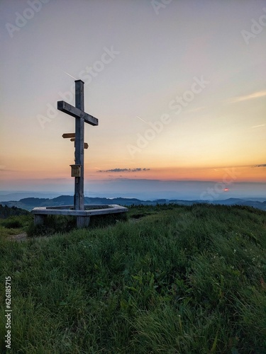 Summit cross on the Hüttchopf in the Zurich Oberland. Sunset on the grass hill above Fischenthal. High quality photo