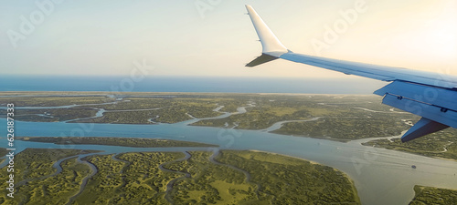 Fotografia A passanger plane wing image with a land bellow