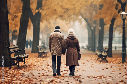 Enduring love and devotion of an old couple as they hold hands and walk together through a picturesque autumn park, celebrating a lifetime of affection and cherished memories. Ai generated © twindesigner