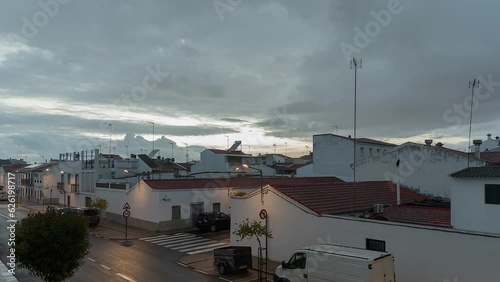 view of a cloudy sunset from a balcony in a village