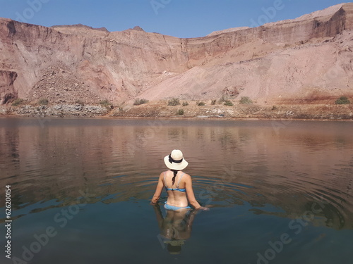 Woman's back in a lake in the middle of the desert