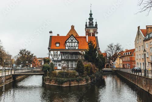 View of beautiful big home in middle of river with bridge and tower bell