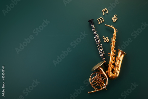 Music lesson school education concept. Wind instruments on green chalkboard. photo