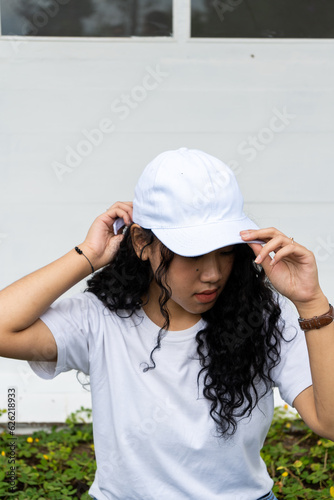 The image portrays a woman wearing a white hat, striking a simple yet stylish pose, perfect for mockup purposes