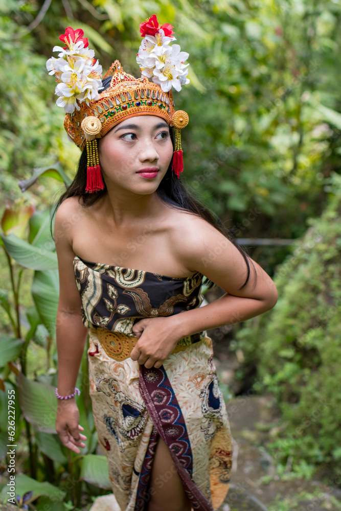 Fototapeta premium Nice Bali female in traditional costume at Bali island, Indonesia. Bali is one of the most popular tourist destinations in Indonesia.